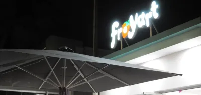 Η φωτεινή ταμπέλα froyart πάνω από το μαγαζί, νύχτα.